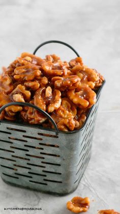 a metal basket filled with nuts on top of a table