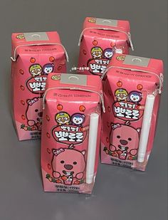 four pink bags with cartoon characters on them and one has a white candle in the middle