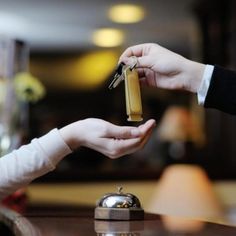 two people are handing something to each other in front of a hotel sign that reads oak 58