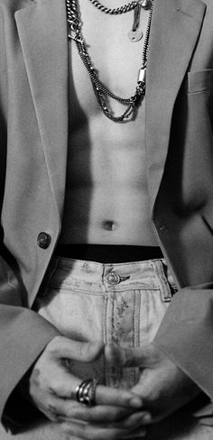 black and white photograph of a shirtless man with his hands in his pockets,