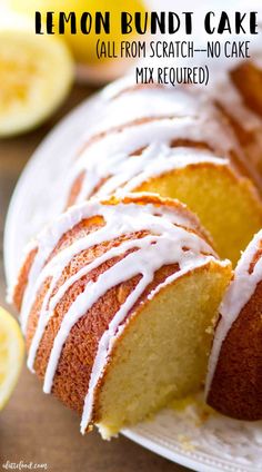 a lemon bunt cake with white icing on a plate next to sliced lemons