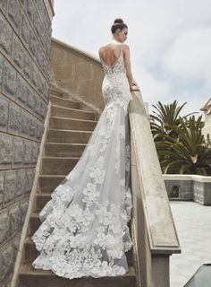 a woman in a wedding dress standing on some stairs