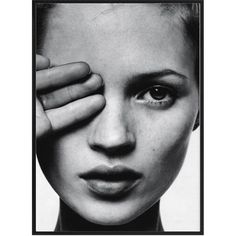 a black and white photo of a woman holding her hand up to her face with the eye