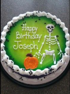 a birthday cake with a skeleton and pumpkin on it