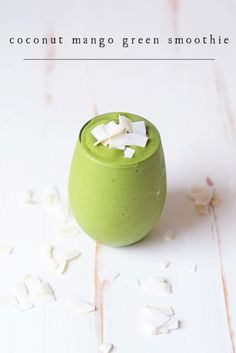 a green cup filled with white marshmallows on top of a table