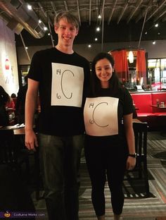 a man and woman standing next to each other holding up signs with the letter c on them