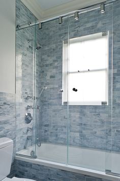 a white toilet sitting next to a bath tub in a bathroom under a skylight