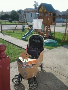 a child's stroller with a cardboard box in the shape of a dog