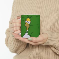 a woman holding a coffee mug with the simpsons on it