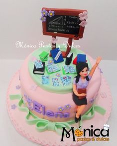 a birthday cake with a woman sitting on top of it and writing on the board