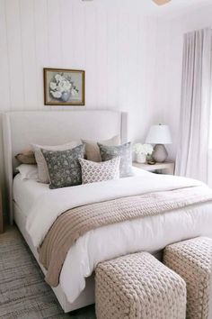 a bedroom with white walls and neutral bedding