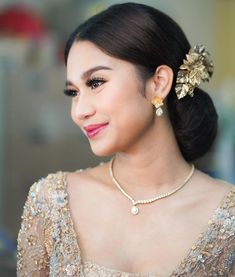 a woman wearing a gold necklace and earrings