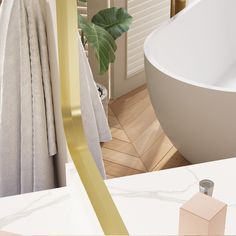 a white bath tub sitting next to a bathroom sink with gold trim on the edge