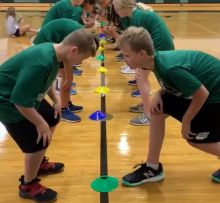 several young boys are playing with plastic cups on the floor in an indoor gym area