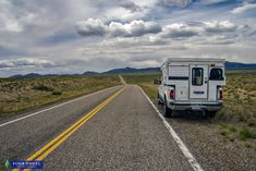 the truck is parked on the side of the road in the middle of the desert