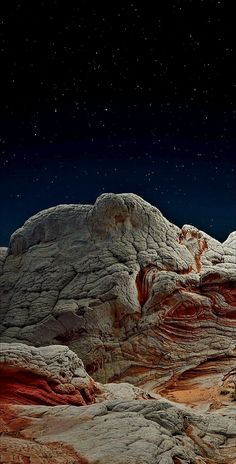 an image of some rocks under the stars in the night sky with no one on it