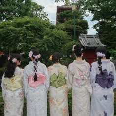 four women in kimonos are looking at the sky and trees, while one woman is wearing a flowered headpiece