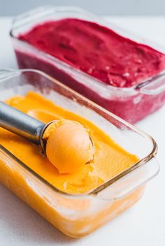 two containers filled with different types of ice cream and one has an ice cream scooper in it