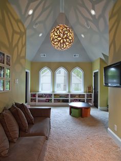 a living room filled with furniture and a flat screen tv mounted on the wall above it