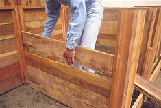 a man standing on top of a wooden box in the middle of some wood pallets