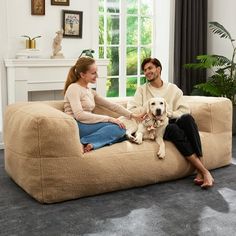 a man and woman sitting on a dog bed