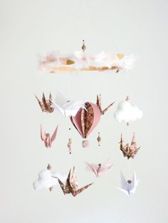 an origami mobile with birds and clouds hanging from it