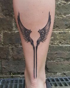 a woman's leg with two birds on it, and one bird is in the middle