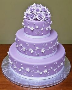 a purple wedding cake with white flowers on top