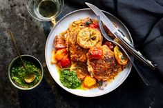 a white plate topped with meat and veggies next to two bowls of pesto sauce