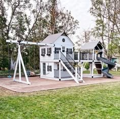 a white house with a swing set and slide in the yard next to some trees