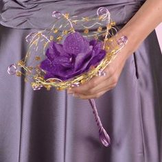 a woman in a purple dress holding a flower