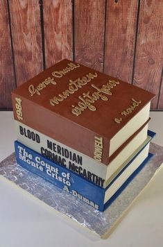 a cake made to look like three books stacked on top of each other with writing on them