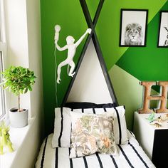 a bedroom decorated in green and white with pictures on the wall