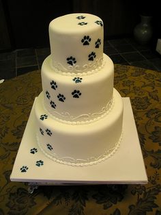 a three tiered cake with paw prints on it