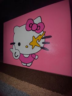 a hello kitty painted on the side of a pink wall with gold stars and a star