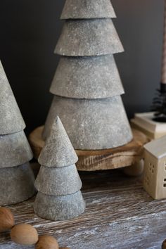 three cement christmas trees sitting on top of a wooden table