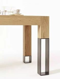 a wooden table with metal legs and a glass on top