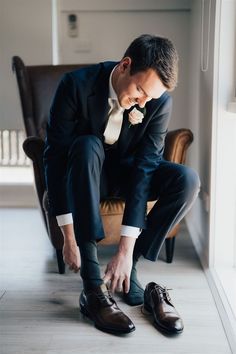 a man in a suit tying his shoes