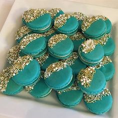 there are many blue and gold decorated cookies on the plate with white trimmings