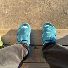 someone wearing blue shoes sitting on a bench