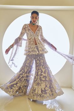 This sharara set features intricate pearls, sequins, and crystal embroidery. The mauve peplum top shows a plunging neckline with pearl and crystal detail. The heavily embroidered dupatta shows crystal tassels on all four sides.From Seema Gujral's Fiori collection. DELIVERY TIMEPlease allow 8-12 weeks for your outfit to arrive. FABRIC DETAILSNet Professional cleaning only. Luxury Chinon Sharara With Dupatta, Luxury Silk Sharara For Traditional Ceremonies, Luxury Sharara With Unstitched Blouse For Reception, Luxury Floral Print Georgette Sharara, Luxury Sharara With Printed Motifs For Women, Luxury Sequined Anarkali Set For Festivals, Luxury Lace Sharara For Wedding, Luxury Embellished Sharara For Formal Occasions, Luxury Sharara With Dabka Work