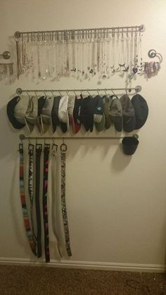 there is a rack with hats and ties hanging from it's hooks on the wall