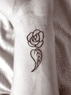 a small rose tattoo on the wrist