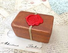 a waxed seal sitting on top of a wooden box next to an old letter