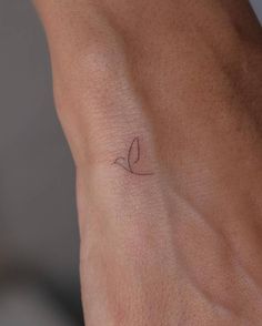 a person's arm with a small tattoo on the left side of their wrist