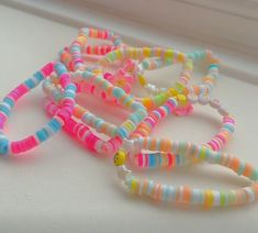 several bracelets are lined up on a window sill