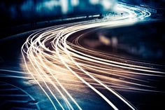 a blurry photo of train tracks in the night time with light streaks on them