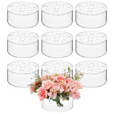 twelve clear glass vases with pink flowers in the center and eight on each side