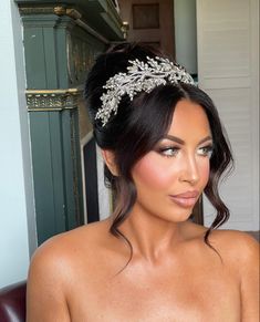 a woman wearing a tiara sitting in a chair