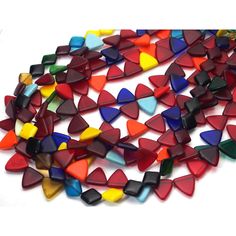 multicolored glass hearts are laid out on a white surface, ready to be used as decorations